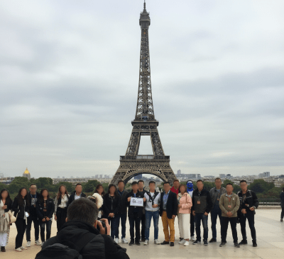 Grupo de empleados frente a la Torre Eiffel en París, durante un viaje de incentivo corporativo.